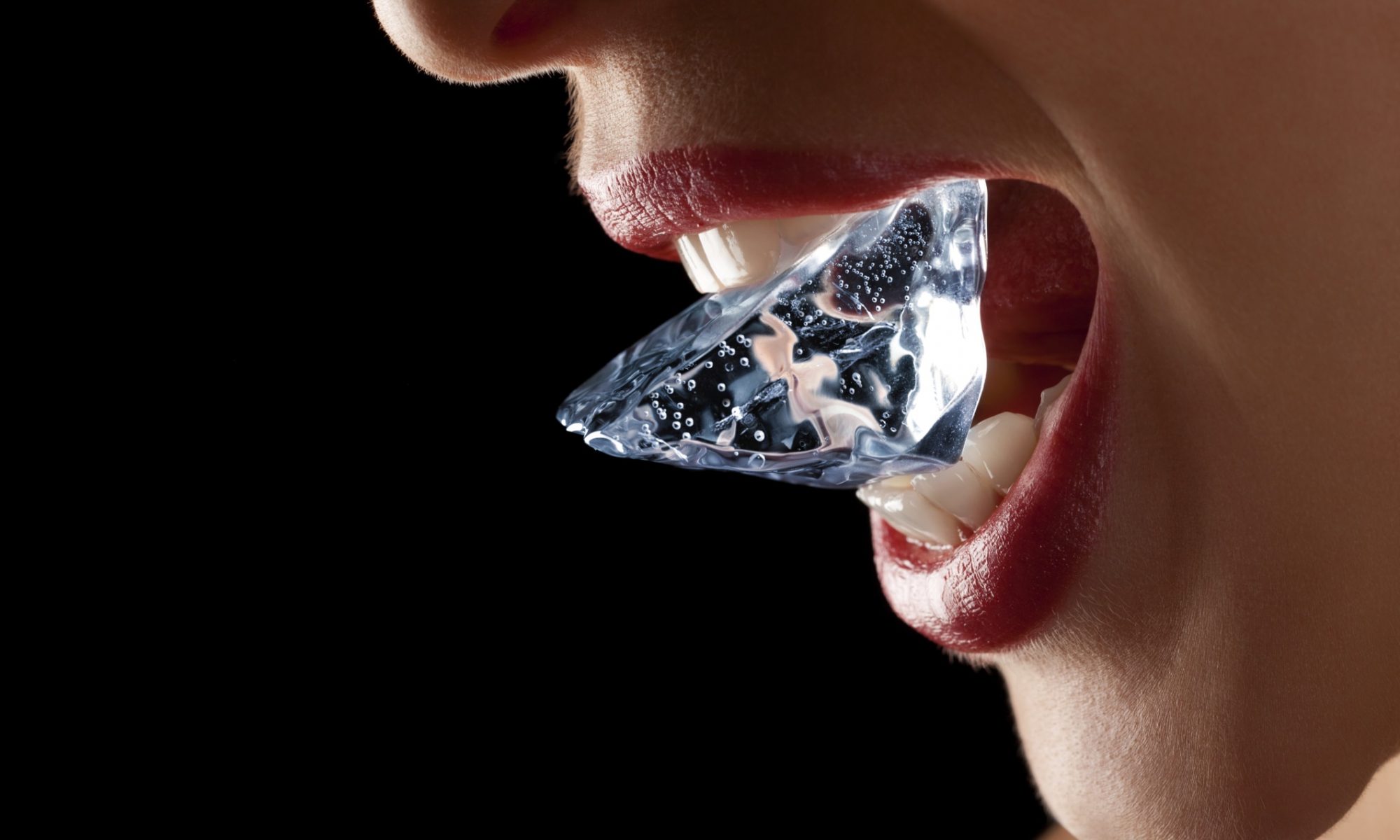 A woman with a large ice cube to show the drinking water is important for our oral health